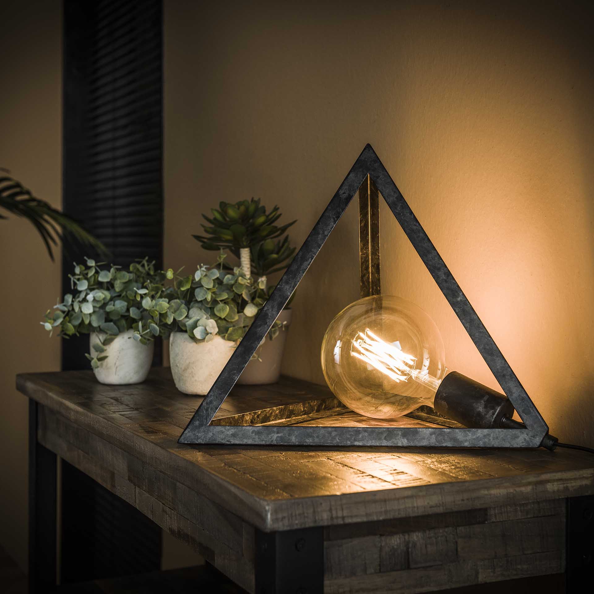 Pyramideformet bordlampe i patineret sort metal.